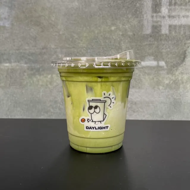 Daylight Coffee iced matcha latte in a branded clear cup